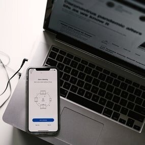 Foto: Sicht von oben auf Handy und Laptop mit geöffneten Web Anwendungen
