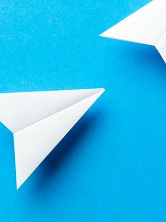 Foto: Papierflugzeuge auf blauem Hintergrund