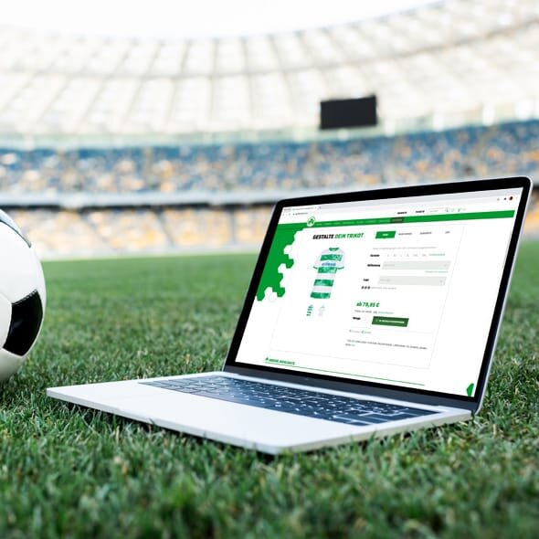 Laptop auf Fußballplatz, Online-Shop im Browser geöffnet