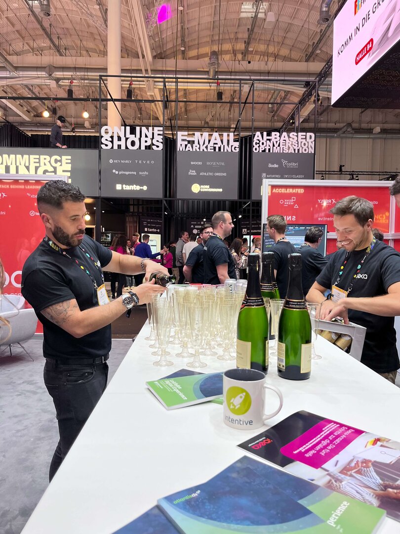 Foto: Ibexa Mitarbeiter schenkt Champagner in Gläser auf der OMR 2023