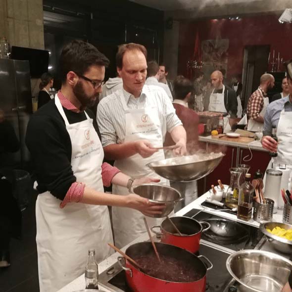 Foto: Mitarbeiter von atlantis dx kochen zusammen, rühren in einem Topf