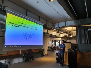 atlantis dx - Smart Datalytics 2019 Foto: Ein Mann präsentiert Inhalte auf einem großen Bildschirm in einem modernen Raum