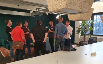 atlantis dx - Smart Datalytics 2029 Foto: Eine Gruppe von Menschen diskutiert in einem modernen Raum