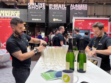 Photo: Ibexa employee pouring champagne into glasses at OMR 2023