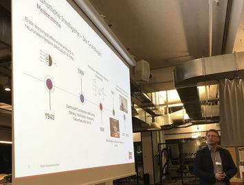 atlantis dx - Smart Datalytics 2019 Foto: Mann präsentiert Informationen auf einer Folie in einem modernen Raum