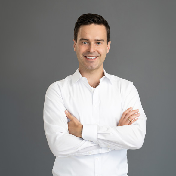 atlantis dx - Radek Paluszak, Geschäftsleitung | Partner Foto: Frontalaufnahme von Radek Paluszak, lächelt, weißes Hemd, Hintergrund dunkel