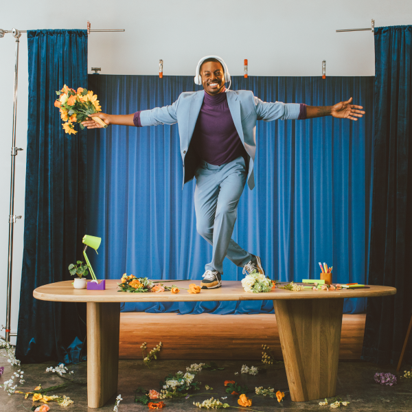 atlantis dx Zendesk Suite Vorteile Ein Mann steht auf einem Tisch und hält Blumen.